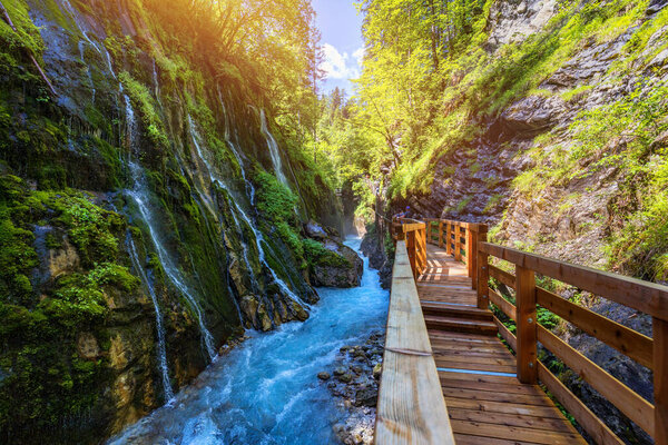 Beautiful Wimbachklamm gorge with wooden path in autumn colors, Ramsau bei Berchtesgaden in Germany. Waterfall at Wimbachklamm near Ramsau-Berchtesgaden, Bavaria, Germany.