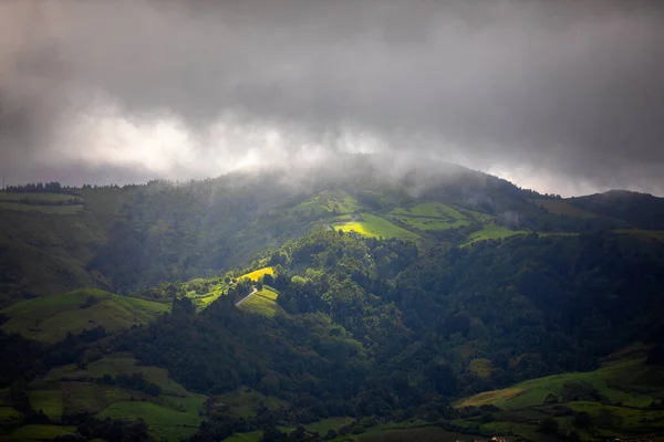 구멍을 빛나는 포르투갈 미구엘의 아조레스 산맥의 어두운 풍경으로 비치고 포르투갈의 — 스톡 사진