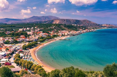 Yunanistan tatilleri, Yunanistan 'ın Girit adasında turkuaz denizli güzel Kalyves köyü. Girit 'teki Kalyves plajı manzarası. Plajda dinlenen turistler ve dağlara, Kalyves, Girit, Yunanistan manzaraları