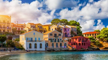 Yunanistan 'ın Kefalonya kentindeki Assos köyünde güzel renkli evleri olan Akdeniz' deki turkuaz renkli körfez. Akdeniz 'de renkli evleri olan Assos kasabası, Yunanistan. 