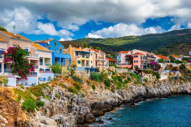 Yunanistan 'ın Kefalonya kentindeki Assos köyünde güzel renkli evleri olan Akdeniz' deki turkuaz renkli körfez. Akdeniz 'de renkli evleri olan Assos kasabası, Yunanistan. 