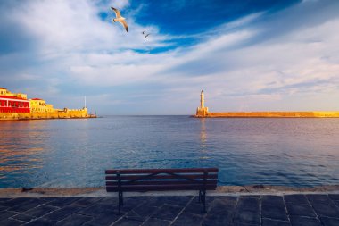 Yunanistan 'ın Girit kentindeki eski Chania limanında, üzerinde martılar uçuşan Venedik limanı ve deniz feneri. Yunanistan, Chania 'daki eski Venedik deniz feneri. Yunanistan 'ın Chania kentindeki eski Venedik limanının deniz feneri.