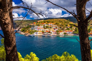 Yunanistan 'ın Kefalonya kentindeki Assos köyünde güzel renkli evleri olan Akdeniz' deki turkuaz renkli körfez. Akdeniz 'de renkli evleri olan Assos kasabası, Yunanistan. 