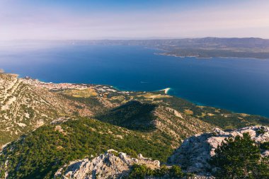 Brac adasındaki Vidova Gora 'dan dağlara ve denize bakın. Hırvatistan 'ın Brac adasındaki Vidova Gora dağından, Bol kenti yakınlarındaki Zlatni Rat ve mavi deniz manzarası.
