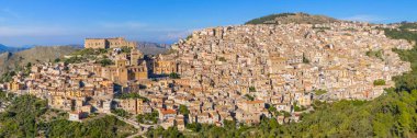 Sicilya 'nın Caccamo şehrinin panoraması. İtalya 'nın Sicilya dağlarında Norman Kalesi olan ortaçağ İtalyan şehri. Tepedeki Caccamo kasabasının arka planında dağlar, Sicilya, İtalya.