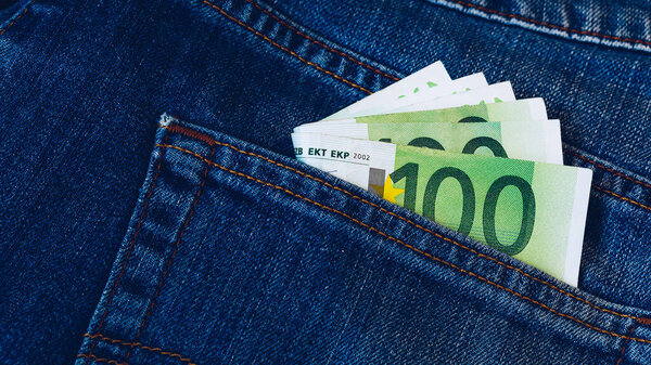 Euro bills in jeans pocket background. Euro banknotes in jeans back pocket. Concept of rich people, saving or spending money. Euro bills falling out. Easy to steal the money. Irresponsible action.