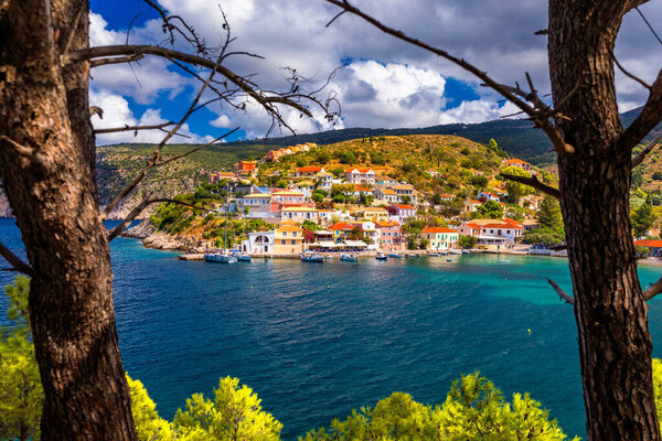 Turquoise colored bay in Mediterranean sea with beautiful colorful houses in Assos village in Kefalonia, Greece. Town of Assos with colorful houses on the mediterranean sea, Greece. 