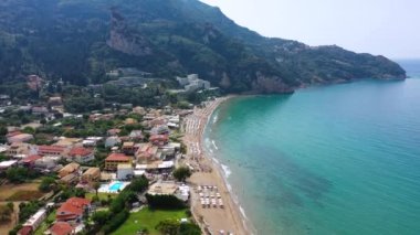 Yunanistan 'ın Korfu adasındaki Agios Gordios egzotik plajı. Agios Gordios plajı, Korfu adası, Yunanistan. Agios Gordios plajının panoramik manzarası, kumlu deniz kıyıları, plaj şemsiyeleri ve şezlonglar..