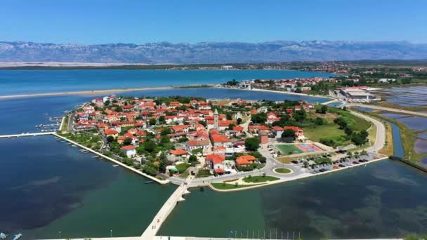クロアチアのダルマチア地方のVelebit山の背景を持つ歴史的な町ニン ラグナ航空ビュー クロアチアの有名なニンラグーンと中世の空中ビュー — ストック動画