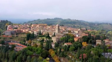 Chiusi village cityscape in Tuscany Italy with orange red rooftop tile houses on mountain countryside and rolling hills. Colorful evening in small town of Chiusi, Tuscany Italy.