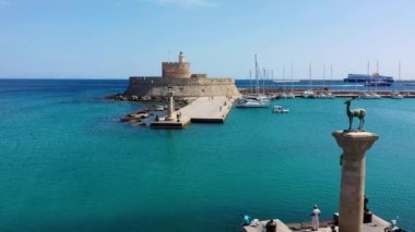 Geyik heykeli olan Mandraki limanı, Heykelin durduğu yer ve Aziz Niklas kalesi. Rodos, Yunanistan. Rodos, Rodos, Yunanistan Heykeli 'nin yerine Hirschkuh heykeli