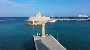 Geyik heykeli olan Mandraki limanı, Heykelin durduğu yer ve Aziz Niklas kalesi. Rodos, Yunanistan. Rodos, Rodos, Yunanistan Heykeli 'nin yerine Hirschkuh heykeli