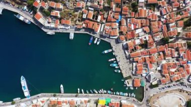 Symi (Simi) ada limanı, klasik gemi yatları, ada tepelerindeki evler, Ege Körfezi manzarası. Yunanistan adaları Rodos adasından tatil turları düzenliyor. Symi, Yunanistan, Dodecanese.