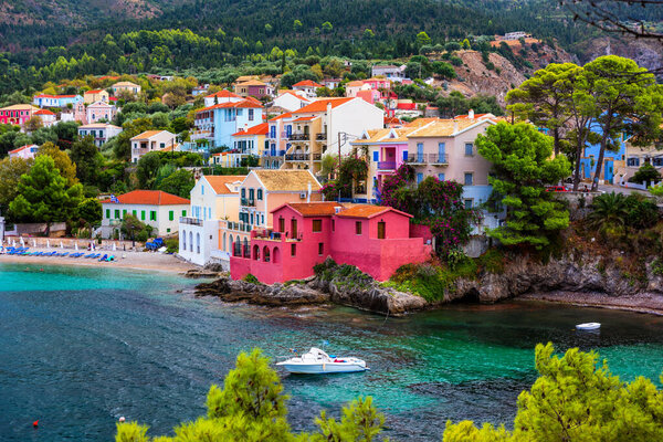 Бирюзовый залив в Средиземном море с красивыми красочными домами в деревне Ассос в Кефалонии, Греция. Town of Assos with colorful houses on the medanean sea, Greece. 
