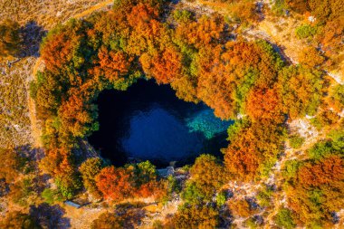 Sonbahar renkleriyle Melissani Mağarası. Yunanistan 'ın Kefalonia adasındaki ünlü Melissani Gölü. Yunanistan 'ın Kefalonya adasındaki Karavomylos köyündeki Melissani Mağarası' nın (Melissani Gölü) tepesinde.. 