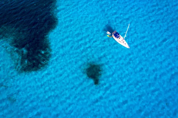 游艇停泊在热带岛屿前方清澈碧绿的海水中 另类的生活方式 住在船上 在蓝绿色的水面上停泊的游艇的空中景象 显示出奢华 — 图库照片