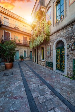 Küçük caddeleri ve çiçekleri olan eski güzel Taormina kasabası. Taormina 'da kemerli ve eski kaldırımlı bir mimari. Eski Taormina kasabasında renkli dar bir cadde. Sicilya, İtalya. 