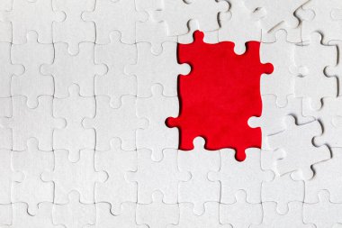 Beyaz yapboz. Renkli arka planda beyaz yapboz parçaları. Renk arkaplanındaki tamamlanmamış beyaz yapboz parçaları. 