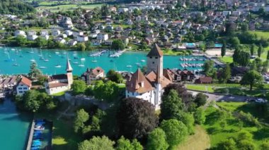 Günbatımında İsviçre kantonundaki Bern kantonunda bulunan Thun Gölü kıyısındaki Spiez Kilisesi ve Kalesi 'nin hava panoramik manzarası, Spiez, İsviçre. İsviçre, Bern kantonunda Thun Gölü 'ndeki Spiez Şatosu.