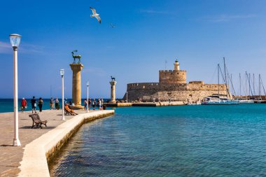 Geyik heykeli olan Mandraki limanı, Heykelin durduğu yer ve Aziz Niklas kalesi. Rodos, Yunanistan. Rodos, Rodos, Yunanistan Heykeli 'nin yerine Hirschkuh heykeli