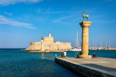 Geyik heykeli olan Mandraki limanı, Heykelin durduğu yer ve Aziz Niklas kalesi. Rodos, Yunanistan. Rodos, Rodos, Yunanistan Heykeli 'nin yerine Hirschkuh heykeli
