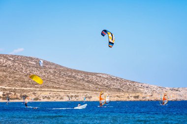 Surfers in Prasonisi Beach in Rhodes island, Greece. Kiteboarder kitesurfer athlete performing kitesurfing kiteboarding tricks. Prasonisi Beach is popular location for surfing. Greece