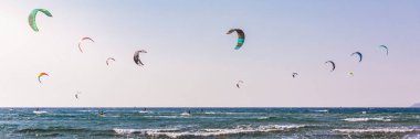 Surfers in Prasonisi Beach in Rhodes island, Greece. Kiteboarder kitesurfer athlete performing kitesurfing kiteboarding tricks. Prasonisi Beach is popular location for surfing. Greece