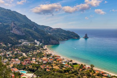 Yunanistan 'ın Korfu adasındaki Agios Gordios egzotik plajı. Agios Gordios plajı, Korfu adası, Yunanistan. Agios Gordios plajının panoramik manzarası, kumlu deniz kıyıları, plaj şemsiyeleri ve şezlonglar..