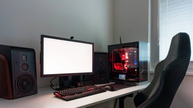 Powerful personal computer gamer rig with white screen. Professsional gaming empty room studio with neon lights and RGB powerful computer, keyboard and mouse. White screen on pc display.