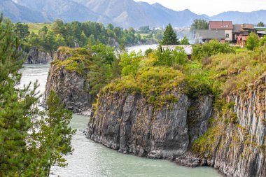 Rusya, Gorny Altai, Chemal köyü yakınlarındaki Turkuaz Katun nehrinin Rocky kıyısında.