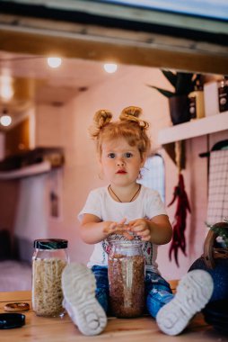 Küçük kız kampa mısır gevreği serpiyor.