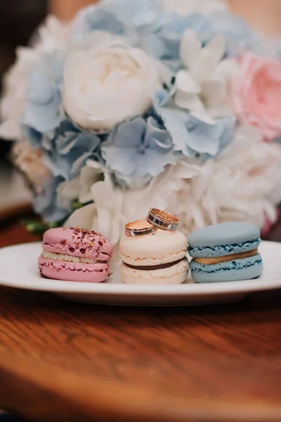 Wedding rings with macaroons and wedding bouquet