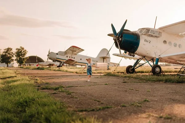 Girl play at the airport in front of a huge airplane