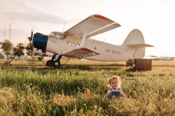 Girl play at the airport in front of a huge airplane