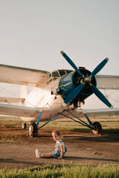 Girl play at the airport in front of a huge airplane