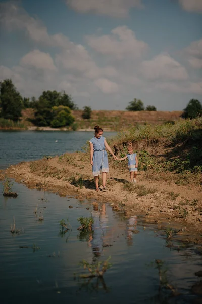 Mother and daughter running on the lake
