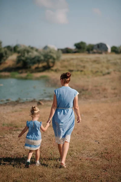 Mother and daughter running on the lake