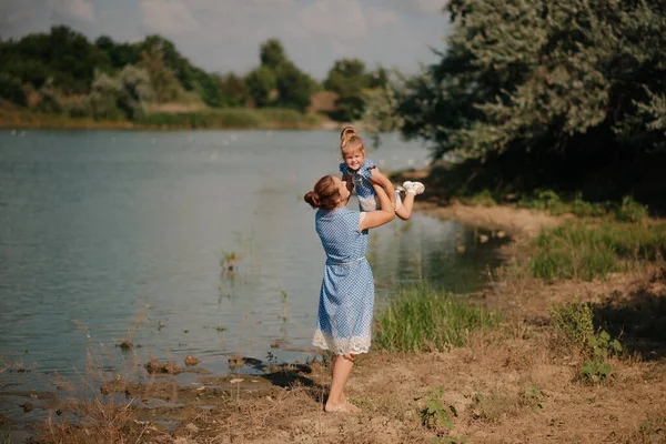 Anne ve kızı gölde oynuyorlar.