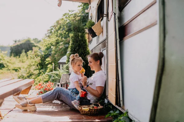Little girl wih her mother play in a camping in summer