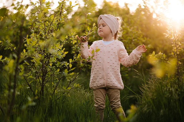 Little Girl Smells Lilac Sunset — Zdjęcie stockowe