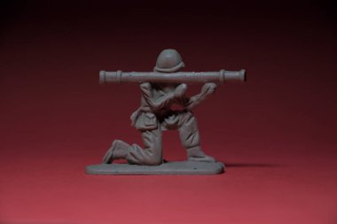 Elinde silah olan minyatür oyuncak asker, kırmızı bir geçmişi var.