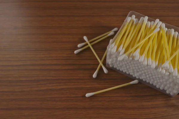 Yellow cotton swabs scattered on the surface.