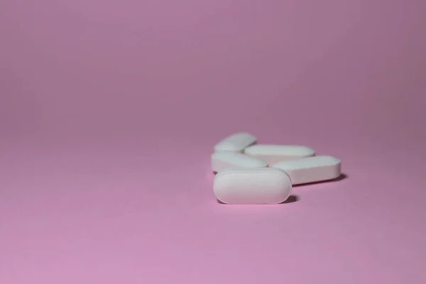 Pembe yüzeye yayılmış beyaz ilaç ya da ilaçlar