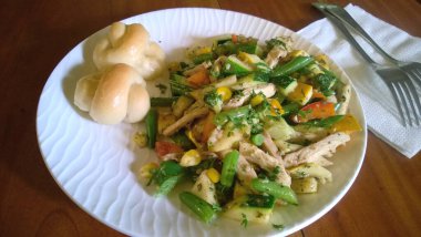 Parçalanmış tavuk ve çeşitli sebzeler ve mini Challah dürümleri ya da bükülmüş ekmekler.