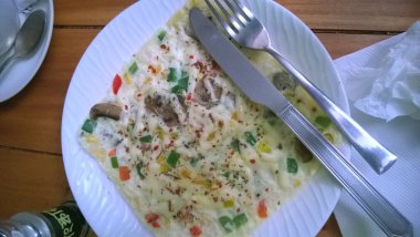 Masada çatal ve bıçakla servis edilen, lezzetli sebzeli omlet ya da omlet. Üst görünüm.