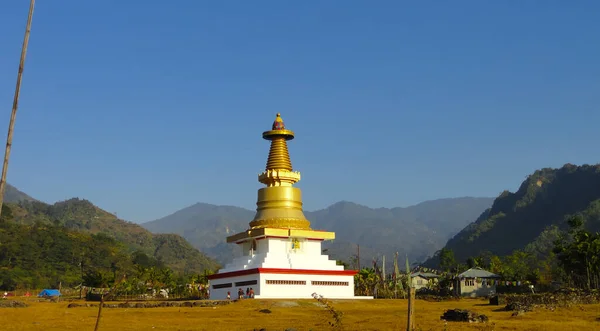 Küçük altın bir Budist Stupa Mavi gökyüzü ve arkasında tepeler