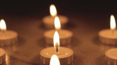 Tealight candles in the dark. Camera sliding one end to another. 