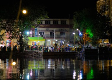 Daldırma Ghat. Durga puja Vijayadashami, Dussehra, Dasara olarak da bilinir. Elveda demek için balçık heykelleri suya dalmadan önce geçit töreni. Geniş açı.
