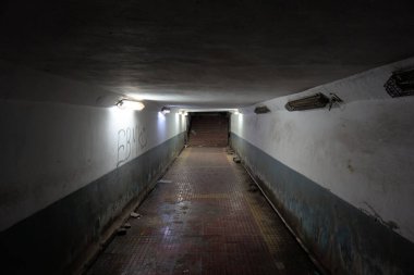 Gece vakti şehrin yeraltı yaya geçidi. Yaşlı, grunge, kötü aydınlatılmış, ürkünç.