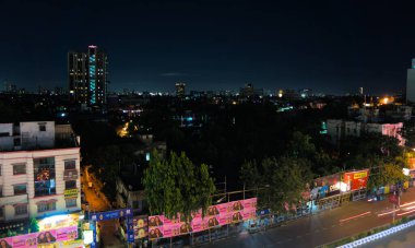 Şehir manzarası, festival gecesi Kolkata 'nın silueti. Aşağıda dekore edilmiş bir sokak var..